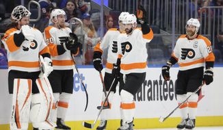 Philadelphia Flyers defenseman Keith Yandle (3) acknowledges the crowd after it is announced that he set NHL&#39;s record by playing in his 965th consecutive game in the first period of an NHL hockey game against the New York Islanders, Tuesday, Jan. 25, 2022, in Elmont, N.Y. (AP Photo/Corey Sipkin)