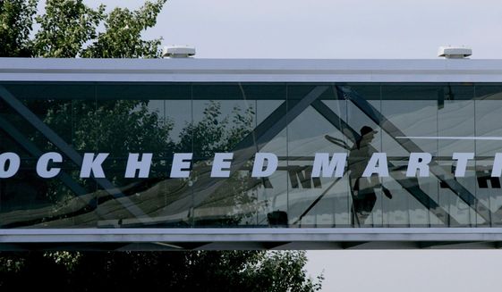 A man walks past a Lockheed Martin logo as he walks through a section of the company&#39;s chalet bridging a road at Farnborough International Airshow in Farnborough, southern England, Wednesday July 19, 2006. The Biden administration is suing to block a Lockheed Martin acquisition that it says would limit competition among companies that supply missiles to the Pentagon. The Federal Trade Commission said Tuesday, Jan. 25, 2022 that the $4.4 billion deal would eliminate the last independent U.S. supplier of key missile parts. (AP Photo/Matt Dunham, FILE)