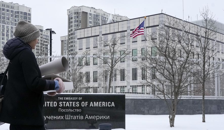 A woman walks past the U.S. Embassy in Kyiv, Ukraine, Monday, Jan. 24, 2022. The State Department is ordering the families of all American personnel at the U.S. Embassy in Kyiv to leave the country and allowing non-essential staff to leave Ukraine. The move comes amid heightened fears of a Russian invasion of Ukraine despite talks between U.S. and Russian officials. (AP Photo/Efrem Lukatsky)