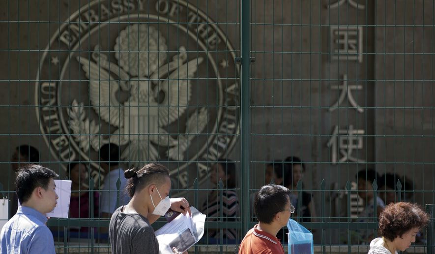In this July 26, 2018, file photo, visa applicants wait to enter the U.S. Embassy in Beijing, China. (AP Photo/Ng Han Guan, File)