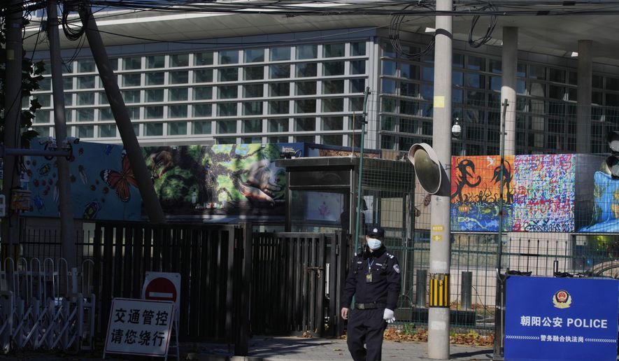 A police officer patrols outside the U.S. Embassy in Beijing, China, Tuesday, Nov. 9, 2021. China on Wednesday expressed “serious concerns and dissatisfaction” with the United States over reports of an internal State Department request to allow the departure of diplomats and their families from China amid tightening anti-pandemic measures. (AP Photo/Ng Han Guan, File)
