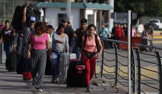 A group of Mexican workers with seasonal jobs awaiting them in the U.S. walk with their luggage across the Puerta Mexico international bridge toward Brownsville, Texas, in Matamoros, Tamaulipas state, Mexico, on June 27, 2019. Mexico’s remittances, the money migrants send home to their relatives, have soared in the past two years, and are now expected to top $50 billion for the first time in 2021, surpassing almost all other sources of foreign income. (AP Photo/Rebecca Blackwell) **FILE**