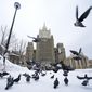 Pigeons take off in front of the Russian Foreign Ministry building in Moscow, Russia, Wednesday, Jan. 26, 2022. Russian Foreign Minister Sergey Lavrov said he and other top officials will advise President Vladimir Putin on the next steps after receiving written replies from the United States to the demands. Those answers are expected this week — even though the U.S. and its allies have already made clear they will reject the top Russian demands. (AP Photo/Alexander Zemlianichenko)