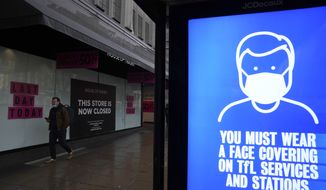 A man wearing a face mask to curb the spread of coronavirus walks past the House of Fraser department store which has closed down during the coronavirus outbreak as a bus stop screen shows a face mask sign, on Oxford Street, in London, Thursday, Jan. 27, 2022. Most coronavirus restrictions including mandatory face masks were lifted in England on Thursday, after Britain&#39;s government said its vaccine booster rollout successfully reduced serious illness and COVID-19 hospitalizations. From Thursday, face coverings are no longer required by law anywhere in England. (AP Photo/Matt Dunham)