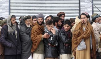 Afghans wait to receive food rations organized by the World Food Program (WFP) in Pul-e-Alam, the capital of Logar province. eastern of Afghanistan, Tuesday, Jan. 18, 2022. The Taliban&#39;s sweep to power in Afghanistan in August drove billions of dollars in international assistance out of the country and sent an already dirt-poor poor nation, ravaged by war, drought and floods, spiralling toward a humanitarian catastrophe. (AP Photo/Zubair Abassi)