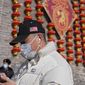 A man wearing a hat baring an American flag and face mask to help protect from the coronavirus walks by a masked security guard near lanterns decoration on the remnants of a city wall in Beijing, Thursday, Jan. 27, 2022. China is demanding the U.S. end “interference” in the Beijing Winter Olympics, which begin next month, in an apparent reference to a diplomatic boycott imposed by Washington and its allies. The Foreign Ministry said Minister Wang Yi made the demand in a phone call with U.S Secretary of State Antony Blinken on Thursday Beijing time. (AP Photo/Andy Wong)