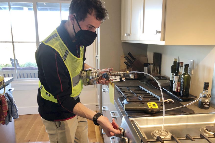 In this photo provided by climate scientist Rob Jackson, researcher Eric Lebel samples natural gas from a stove in Stanford, Calif., in 2021. According to a study published Thursday, Jan. 27, 2022, in the journal Environmental Science & Technology, gas stoves are worse for the climate than previously thought because of constant tiny methane leaks even while they’re off. (Rob Jackson via AP)