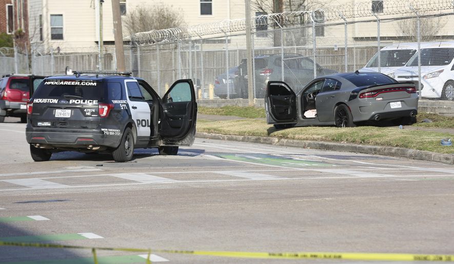 Authorities investigate the scene of a shooting Thursday, Jan. 27, 2022, in Houston. Authorities say a police chase in Houston ended with a shootout that wounded three officers. The incident happened about 2:40 p.m. Thursday when a car that police were pursuing crashed at an intersection just off Interstate 69 on the southeastern edge of downtown Houston. ( Jon Shapley/Houston Chronicle via AP)