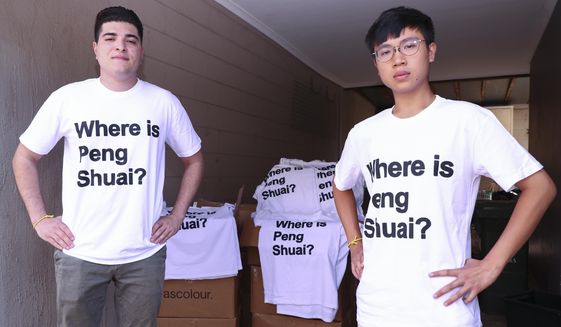 Drew Pavlou, left, and Max Mok show some of the 1,000 shirts they plan to hand out to patrons ahead of Saturday&#39;s women&#39;s singles final at the Australian Open tennis championships in Melbourne, Australia, Friday, Jan. 28, 2022. As he was being ejected for wearing a shirt with a Where is Peng Shuai? slogan, Max Mok saw an opportunity to amplify the message at the Australian Open. (AP Photo/Tertius Pickard)