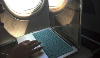 A passenger uses a laptop aboard a commercial airline flight from Boston to Atlanta on July 1, 2017.  Concern about new high-speed wireless service interfering with airplanes appears to be easing. Federal safety regulators said Friday, Jan. 28, 2022 they have cleared the way for Verizon and AT&amp;amp;T to turn on more 5G towers.   (AP Photo/Bill Sikes, File)