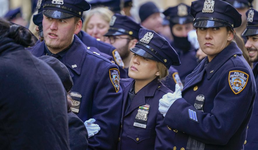 Police officers stand in line outside St. Patricks Cathedral to pay their respects during the wake of New York City Police Officer Jason Rivera, Thursday, Jan. 27, 2022, in New York.  Rivera was fatally shot Friday, Jan. 21, while answering a call about an argument between a woman and her adult son.   (AP Photo/Mary Altaffer)