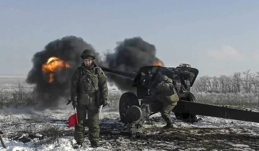 In this photo taken from video provided by the Russian Defense Ministry Press Service on Friday, Jan. 28, 2022, Russian troops fire howitzers during drills in the Rostov region during a military exercising at a training ground in Rostov region, Russia. (Russian Defense Ministry Press Service via AP)