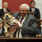 West Virginia Gov. Jim Justice holds up his dog Babydog as he comes to the end of his State of the State speech in the House chambers, at the West Virginia State Capitol in Charleston, W.Va., Thursday, Jan. 27, 2022. (Chris Dorst/Charleston Gazette-Mail via AP)