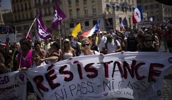 Protesters march during a demonstration to denounce a COVID-19 health pass needed to access restaurant, long-distance trains and other venues. in Marseille, southern France, Saturday, Aug. 14, 2021. The run-up to the April election comes in a context of mounting violence targeting elected officials in France, with holders of public officers targeted for their politics and by opponents of COVID-19 vaccinations restrictions. (AP Photo/Daniel Cole, File)