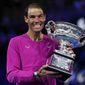 Rafael Nadal of Spain holds the Norman Brookes Challenge Cup after defeating Daniil Medvedev of Russia in the men&#39;s singles final at the Australian Open tennis championships in Melbourne, Australia, early Monday, Jan. 31, 2022. (AP Photo/Hamish Blair)