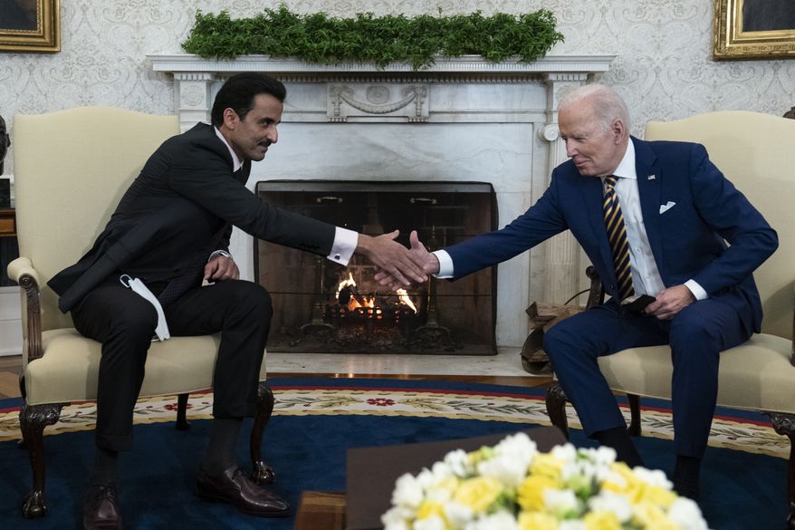 President Joe Biden, right, shakes hands with Qatar's Emir Sheikh Tamim bin Hamad Al Thani in the Oval Office of the White House, Monday, Jan. 31, 2022, in Washington. (AP Photo/Alex Brandon)