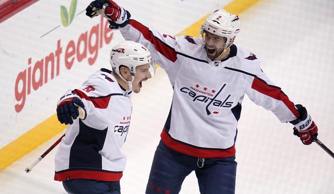 Washington Capitals&#x27; Dmitry Orlov (9) celebrates his goal with Justin Schultz during the first period of an NHL hockey game against the Pittsburgh Penguins in Pittsburgh, Tuesday, Feb. 1, 2022. (AP Photo/Gene J. Puskar)