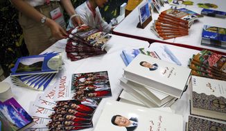 Copies of the book on the governance of Chinese President Xi Jinping are displayed with booklets promoting Xinjiang during a news conference by Shohrat Zakir, chairman of China&#39;s Xinjiang Uighur Autonomous Region, at the State Council Information Office in Beijing on July 30, 2019. As the Chinese government tightened its grip over its ethnic Uyghur population, it sentenced one man to death and three others to life in prison in 2021 for textbooks drawn in part from historical resistance movements that had once been sanctioned by the ruling Communist Party. (AP Photo/Andy Wong, File)