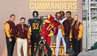 Joe Theismann, Jonathan Allen, and Dan and Tanya Snyder pose with the new Washington Commanders uniforms Wednesday at FedEx Field in Landover MD. (Reggie Hildred/All-Pro Reels)