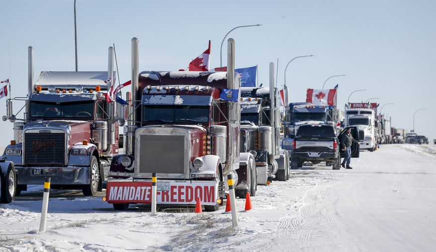 A truck convoy of anti-COVID-19 vaccine mandate demonstrators continues to block the highway at the busy U.S. border crossing in Coutts, Alta., Wednesday, Feb. 2, 2022. (Jeff McIntosh /The Canadian Press via AP)