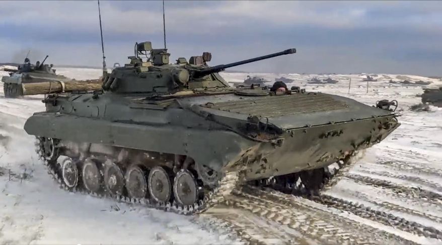 In this photo taken from video and released by the Russian Defense Ministry Press Service on Wednesday, Feb. 2, 2022, Russian and Belarusian armored vehicles drive during a joint military drills at Brestsky firing range, Belarus. Russian and Belarus troops held joint combat training at firing ranges in Belarus Wednesday as tensions remain high under the looming threat of war with Ukraine. The drills involved motorized rifle, artillery and anti-tank missile units, as well tanks' and armoured personnel carriers' crews. (Russian Defense Ministry Press Service via AP)