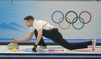 John Morris, of Canada, throws a rock during the mixed doubles curling match against Britain at the Beijing Winter Olympics Thursday, Feb. 3, 2022, in Beijing. (AP Photo/Brynn Anderson) ** FILE**