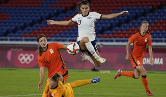 United States&#39; Alex Morgan jumps over Netherlands&#39; goalkeeper Sari van Veenendaal as she attempts to score during a women&#39;s quarterfinal soccer match at the 2020 Summer Olympics, Friday, July 30, 2021, in Yokohama, Japan. The U.S. Equal Employment Opportunity Commission has asked for permission to participate in the appeal by American women soccer players trying to reinstate their pay claim against the U.S. Soccer Federation. The EEOC asked the 9th U.S. Circuit Court of Appeals on Thursday, Feb. 3, 2022, to be allowed to address the court during oral arguments scheduled for March 7 in Pasadena, California.(AP Photo/Kiichiro Sato, File) **FILE**
