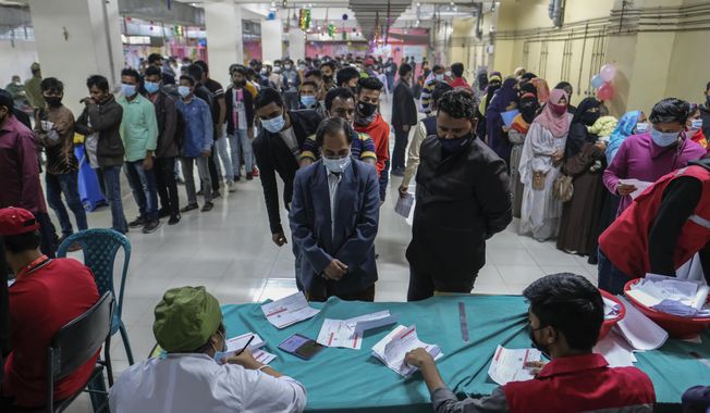 A large number of people line up to receive COVID-19 vaccine amid a surge in coronavirus infections in Dhaka, Bangladesh, Sunday, Jan. 30, 2022. Bangladesh has reported more than 1.8 million COVID-19 cases and over 28,000 deaths since the pandemic started. (AP Photo/Mahmud Hossain Opu)