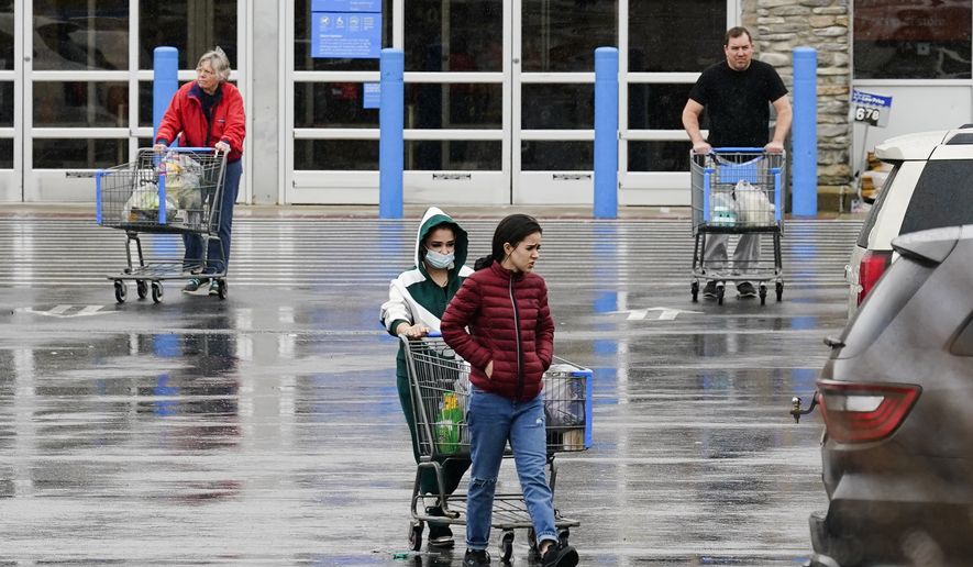 Shoppers exit a Walmart in Warrington, Pa., Friday, Feb. 4, 2022. (AP Photo/Matt Rourke)
