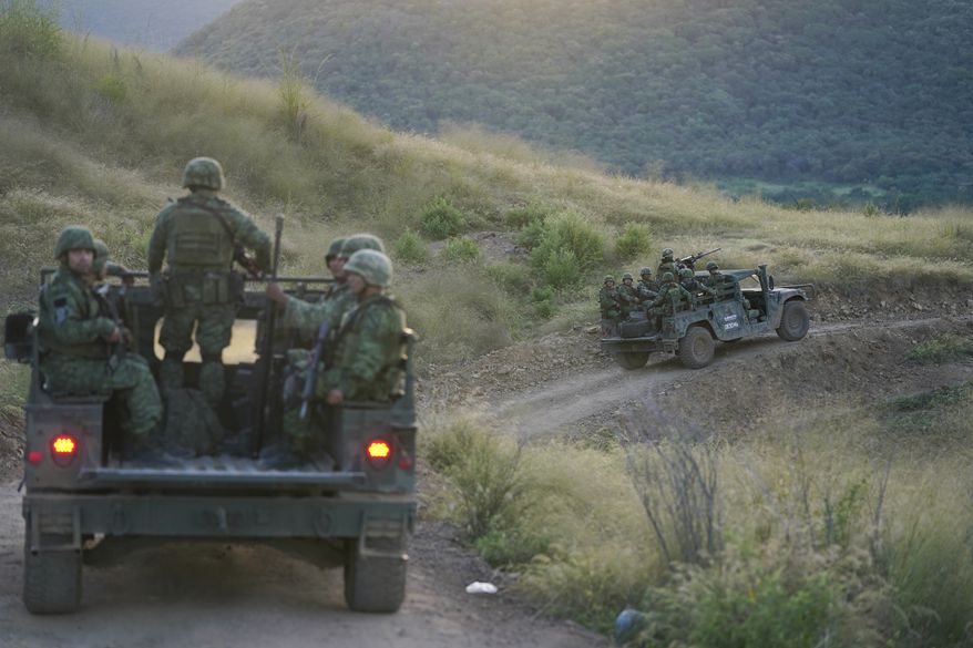 Soldiers patrol near the hamlet Plaza Vieja in the Michoacan state of Mexico, Oct. 28, 2021. The self-defense movement in the nearby town of Tepalcatepec, said improvised land mines severely damaged an army armored car on Saturday, Jan. 29, 2022. In the war raging between drug cartels in western Mexico, gangs have begun using improvised explosive devices (IEDs) on roads to disable army vehicles. (AP Photo/Eduardo Verdugo, File)
