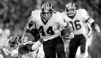 FILE - Washington Redskins running back John Riggins (44) eludes a tackle-attempt by Miami Dolphins&#39; Don McNeal (28) during NFL football&#39;s Super Bowl XVII in Pasadena, Calif., Jan. 30, 1983. Washington was a power team, using running back — more like a fullback — John Riggins to batter defenses behind the original &amp;quot;Hogs&amp;quot; offensive line. Washington beat Miami 27-17. (AP Photo/File)