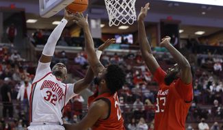 Ohio State&#x27;s E.J. Liddell, left, shoots over Maryland&#x27;s Donta Scott, center, and Qudus Wahab during the second half of an NCAA college basketball game, Sunday, Feb. 6, 2022, in Columbus, Ohio. (AP Photo/Jay LaPrete)
