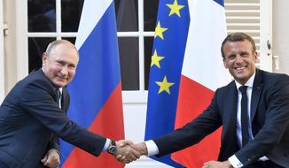 French President Emmanuel Macron, right, shakes hands with Russian President Vladimir Putin after their meeting at the fort of Bregancon in Bormes-les-Mimosas, southern France, on Aug. 19, 2019. Rarely in recent years has the Kremlin been so popular with European visitors. French President Emmanuel Macron arrives Monday, Feb. 7, 2022. The Hungarian prime minister visited last week. And in days to come, the German chancellor will be there, too. (Gerard Julien, Pool via AP, File)