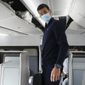 Novak Djokovic prepares to take his seat on a plane to Belgrade, in Dubai, United Arab Emirates, Monday, Jan. 17, 2022. Djokovic was deported from Australia after losing a bid to stay in the country to defend his Australian Open title despite not being vaccinated against COVID-19. Prime Minister Scott Morrison said on Monday, Feb. 7, 2022, that the border would reopen to all vaccinated visas holders from Feb. 21. (AP Photo/Darko Bandic, File)