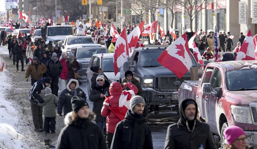 Trucks and supporters travel down Bloor Street during a demonstration in support of a trucker convoy in Ottawa protesting COVID-19 restrictions, in Toronto, Saturday, Feb. 5, 2022. (Nathan Denette/The Canadian Press via AP)