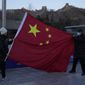 Tourists pose with a Chinese national flag as they visit the Badaling section of the Great Wall of China on the outskirts of Beijing on Tuesday, Feb. 8, 2022, in Beijing. (AP Photo/Ng Han Guan)