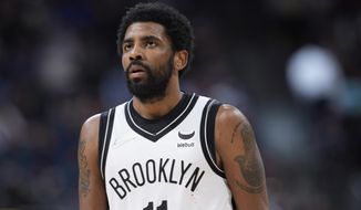 Brooklyn Nets guard Kyrie Irving checks the scoreboard as time runs out in the second half of an NBA basketball game against the Denver Nuggets Sunday, Feb. 6, 2022, in Denver. (AP Photo/David Zalubowski)