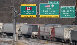 Trucks heading to Canada are stuck in heavy traffic after they were diverted to the Blue Water Bridge in Port Huron, Mich., Wednesday, Feb. 9, 2022, after the Ambassador Bridge was closed due to Canadian anti-vaccine protests. (Mandi Wright/Detroit Free Press via AP)