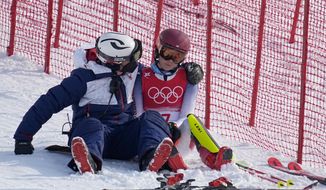 A team member consoles Mikaela Shiffrin, of the United States after she skied out in the first run of the women&#39;s slalom at the 2022 Winter Olympics, Wednesday, Feb. 9, 2022, in the Yanqing district of Beijing. (AP Photo/Robert F. Bukaty)