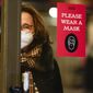 A sign asks shoppers to wear masks in New York, Wednesday, Feb. 9, 2022. New York Gov. Kathy Hochul announced Wednesday that the state will end a COVID-19 mask mandate requiring face coverings in most indoor public settings, but will keep masking rules in place in schools for now. (AP Photo/Seth Wenig)