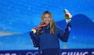 United States&#39; Chloe Kim shows her gold during a medal ceremony for the women&#39;s snowboard halfpipe finals event at the 2022 Winter Olympics, Thursday, Feb. 10, 2022, in Zhangjiakou, China. (AP Photo/Frank Augstein)