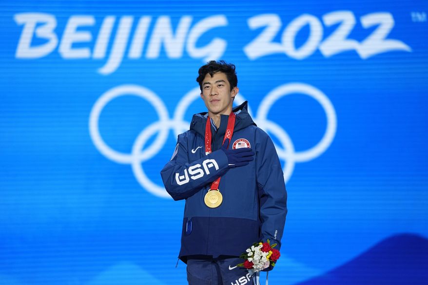 Gold medalist Nathan Chen of the United States stands for his national anthem during the medal ceremony for the men's free skate figure skating at the 2022 Winter Olympics, Thursday, Feb. 10, 2022, in Beijing. (AP Photo/Jae C. Hong)