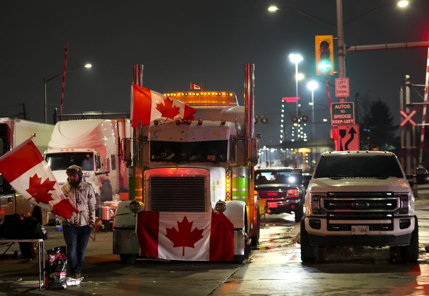 Truckers and supporters block the access leading from the Ambassador Bridge, linking Detroit and Windsor, as truckers and their supporters continue to protest against the COVID-19 vaccine mandates and restrictions in Windsor, Ontario, on Thursday, Feb. 10, 2022. (Nathan Denette/The Canadian Press via AP)