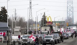 Truckers and supporters block the access leading from the Ambassador Bridge, linking Detroit and Windsor, as truckers and their supporters continue to protest against COVID-19 vaccine mandates and restrictions, in Windsor, Ont., Thursday, Feb. 10, 2022.  (Nathan Denette /The Canadian Press via AP)