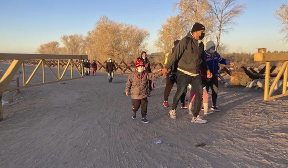 Migrants walk to an area in Yuma, Ariz., Sunday, Feb. 6, 2022, where they surrender to Border Patrol agents. hoping to remain in the United States to seek asylum. For nationalities that don&#39;t need a visa, Mexico is often the ticket to seeking asylum in the United States. (AP Photo/Elliot Spagat)