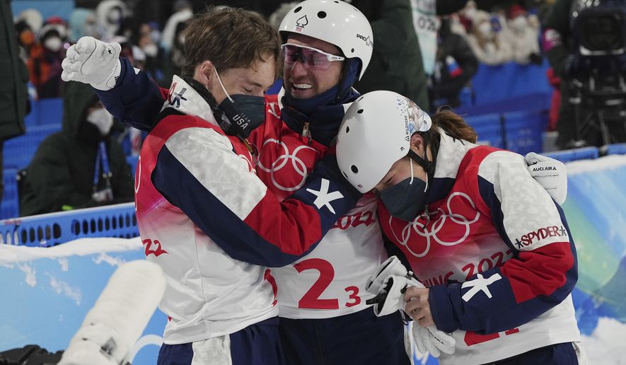 United States&#39; Justin Schoenefeld, center, celebrates with Christopher Lillis, left, and Ashley Caldwell during the mixed team aerials finals at the 2022 Winter Olympics, Thursday, Feb. 10, 2022, in Zhangjiakou, China. (AP Photo/Gregory Bull)