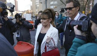 Sarah Palin is escorted to her car by Ron Duguay after leaving the courthouse in New York, Thursday, Feb. 10, 2022. Former Alaska Gov. Sarah Palin told a jury Thursday she felt like she was at the mercy of a “Goliath” when she first learned a 2017 New York Times editorial suggested her campaign rhetoric helped incite a mass shooting.(AP Photo/Seth Wenig)
