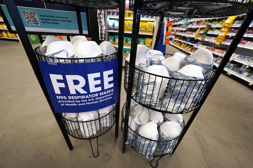 A product stall filled with free N95 respirator masks, provided by the U.S. Department of Health and Human Services, sits outside the pharmacy at this Jackson, Miss., Kroger grocery store Wednesday, Feb. 2, 2022. As the omicron wave of the coronavirus subsides, several U.S. states including New York and Illinois ended mask mandates this week for indoor settings, while others lifted requirements at schools. (AP Photo/Rogelio V. Solis)