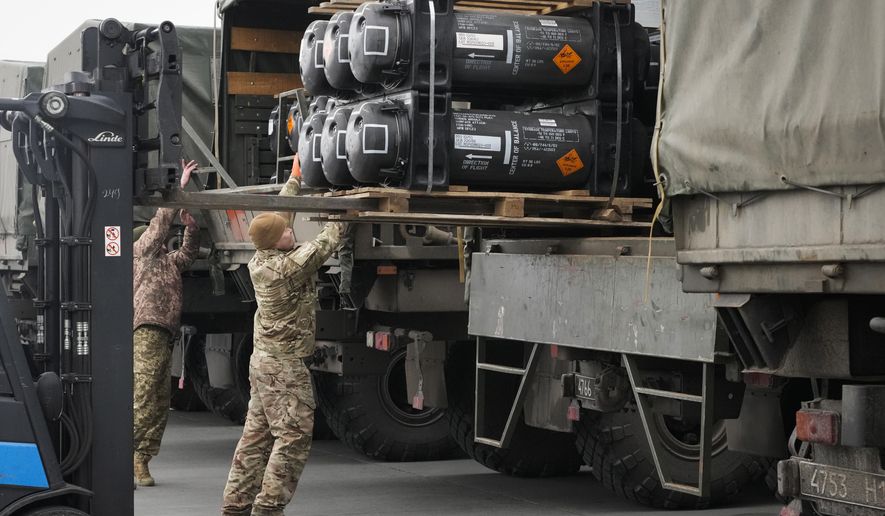 Ukrainian servicemen load Javelin anti-tank missiles, delivered as part of the United States of America&#x27;s security assistance to Ukraine, into military trucks at the Boryspil airport, outside Kyiv, Ukraine, Friday, Feb. 11, 2022. The Polish military, meanwhile, has made an urgent request for 1,000 U.S. Army Javelin anti-tank missiles earlier this month but Pentagon red tape is delaying efforts to get large numbers of the missiles to the Ukrainian military. (AP Photo/Efrem Lukatsky)
