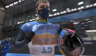 In this frame from video, Vladyslav Heraskevych, of Ukraine, holds a sign that reads &amp;quot;No War in Ukraine&amp;quot; after finishing a run at the men&#39;s skeleton competition at the 2022 Winter Olympics, Friday, Feb. 11, 2022, in the Yanqing district of Beijing. (NBC via AP)